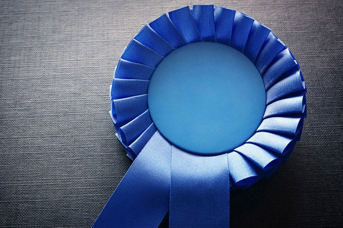 Blue ribbon against a gray background. Ruban bleu sur fond gris.