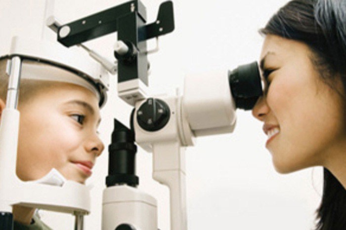 Vision Centre associate checks a patient's eyes.L'associé du Centre de vision vérifie les yeux d'un patient.