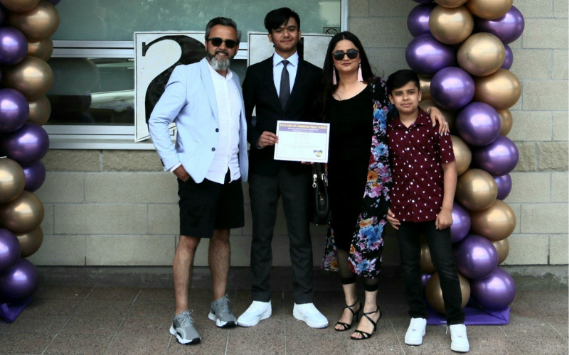 Shahpoor Amiri poses with his wife and two sons to celebrate his oldest son's Grade 8 graduation.